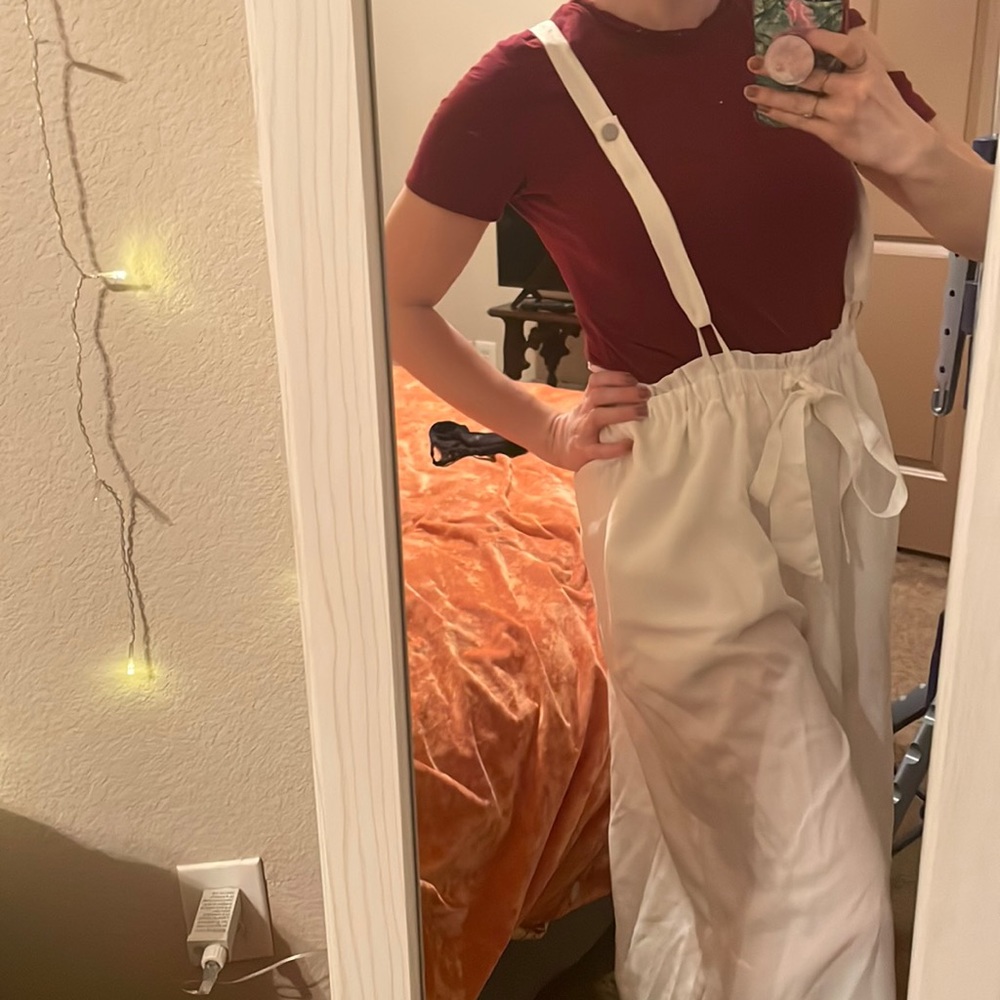 White ruffle waisted suspender pants w/ a tie around waist. From brand sensemill